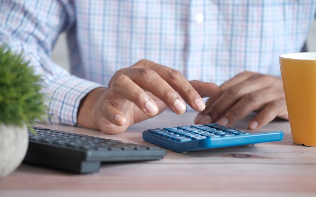 A close up photo of a man's hands using a calculator