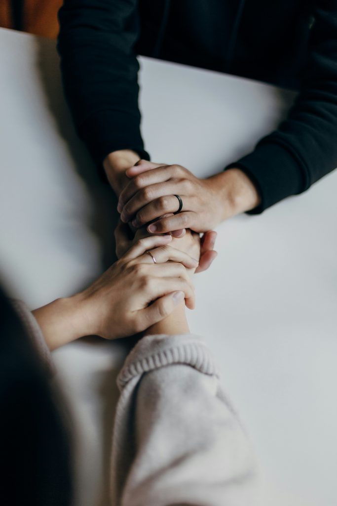 Two people holding hands across a table